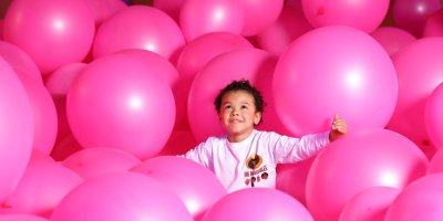 Dream Point 2 Young child playing surrounding by pink inflatables